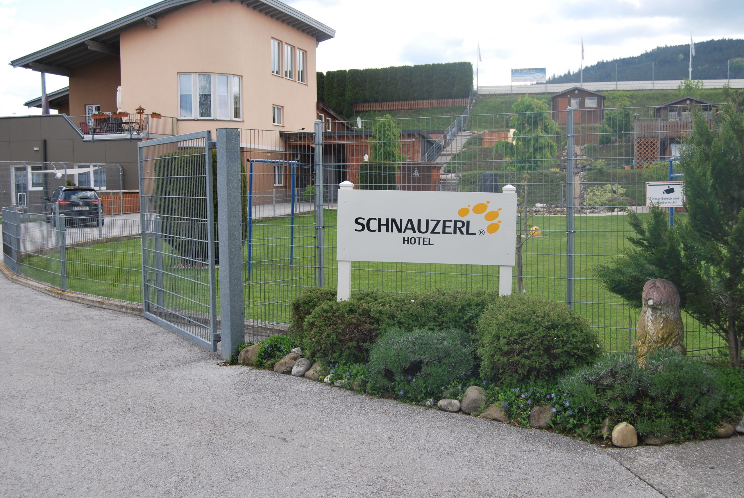 Einfahrt zum SCHNAUZERL Hotel mit Firmenschild