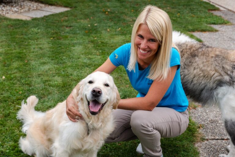 Betreuerin mit einem Hund auf der Wiese